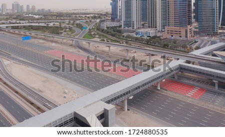 Aerial view of empty highway and interchange in Dubai after epidemic lockdown. Cityscapes with disappearing traffic on streets. Roads and lanes crossroads without cars, Dubai marina and JLT, United
