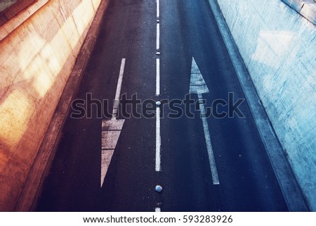 Aerial view of empty two lane road with opposite direction arrows