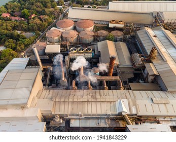 Aerial View Of Ethanol Industrial Or Biofuel Refinery Processing Factory With Smoke From Chimney, Storage Tanks And Warehouse. Problem Of Pollution Climate And Global Warming