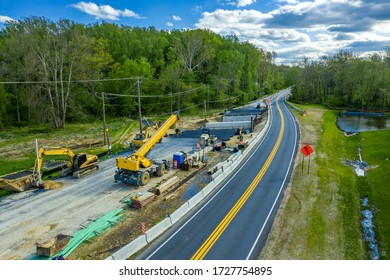 Aerial View Of Expanding A Two Lane Road To A Four Lane Highway With Heavy Construction Equipment Such As Cranes Parked For The Weekend Before A Small Bridge Is Completed In Maryland USA