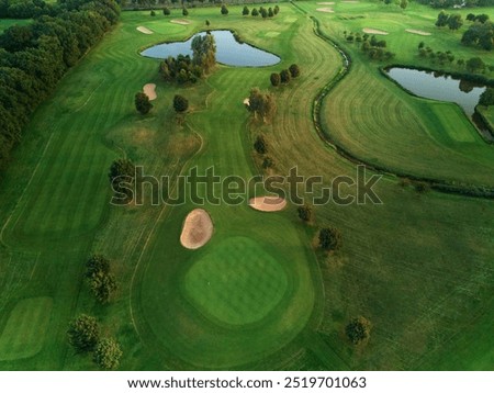 Similar – A tranquil aerial view of a lush golf course fairway, bathed in the warm glow of sunset. Ideal for themes of relaxation, nature, and sports, this image captures the peaceful beauty of the golfing experience.