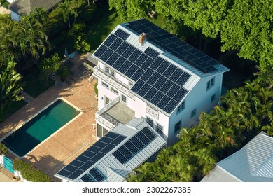 Aerial view of expensive american home roof with blue solar photovoltaic panels for producing clean ecological electric energy. Investing in renewable electricity for retirement income - Powered by Shutterstock