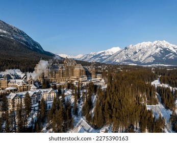  aerial view of Fairmont Banff Springs hotel during winter sunrise in banff with mountains on background