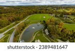 An Aerial View of Fall Countryside of Sun and Color with a Pond and American Flag on a Sunny Autumn Day