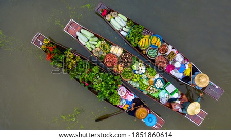 Aerial view famous floating market in Thailand, Damnoen Saduak floating market, Farmer go to sell organic products, fruits, vegetables and Thai cuisine, Tourists visiting by boat, Ratchaburi, Thailand