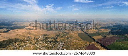 Aerial view of farm fields and distant scattered houses in rural area