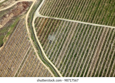 An aerial view of a farmer spraying insecticide on a dormant apple orchard. - Powered by Shutterstock