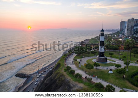 Aerial view of Faro la Marina located in Miraflores's park by the ocean in Lima, Peru. People, tourists and cyclists having fun in 