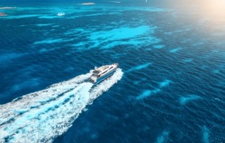 Aerial View Of Fast Floating Yacht On Blue Sea At Sunny Day In Summer. Travel In Sardinia, Italy. Aerial View Of Speed Boat, Sea Lagoon, Transparent Azure Water. Top Drone View. Tropical Seascape
