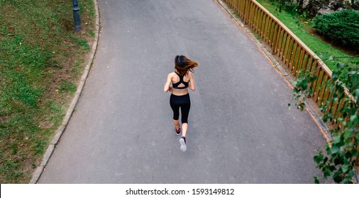 Aerial View Of Female Athlete Backwards Running On A Road