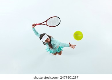 Aerial view of female tennis player, sportsman in mid-action, serving ball against white studio background. Concept of professional sport, championship, active lifestyle, tournament. Ad - Powered by Shutterstock