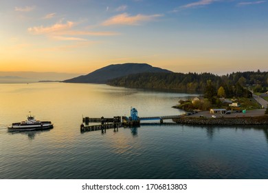 Aerial View Of A Ferry Boat Landing At The Island Dock. Aerial Shot Of A Small 21 Car Ferry Landing At The Lummi Island Ferry Dock On A Beautiful Sunlit Morning In The The Pacific Northwest, USA.