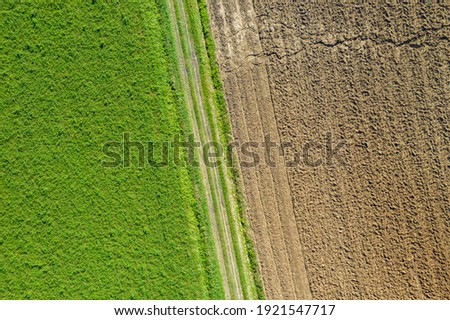 Aerial view of fertile and dry arid terrain. Grooves in the fields seen from above. Climate change concept, arid land, desertification. Copy space, texture, background
