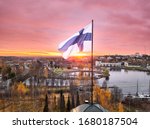 Aerial view of Finnish flag on the tower of Town Hall against the red sunrise sky in Joensuu, Finland.