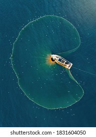 Aerial view fisherman catching fish using net at the ocean.