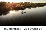 An aerial view of a fisherman with a fishing boat in the middle of the lake Grand, Oklahoma at sunset