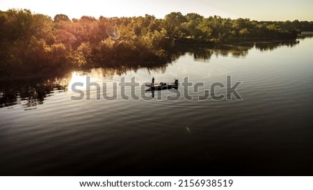 An aerial view of a fisherman with a fishing boat in the middle of the lake Grand, Oklahoma at sunset