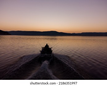 Aerial View Of A Fishermens On A Speed Motor Boat Fishing On A Lake With Beautiful Sunrise