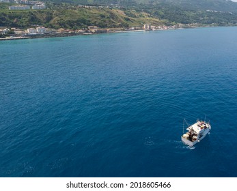 Aerial View Of A Fishing Vessel In The Blue Sea Off The Coast Of Calabria, Italy