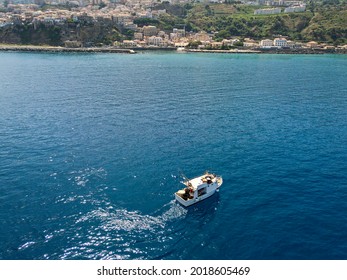 Aerial View Of A Fishing Vessel In The Blue Sea Off The Coast Of Calabria, Italy