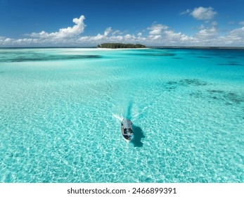 Aerial view of floating boat in clear azure water on summer day. Mnemba island, Zanzibar. Top view of yacht, sandbank in low tide, clear blue sea, sand, sky with clouds. Ideal for vacation, travel - Powered by Shutterstock