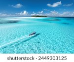 Aerial view of floating boat in transparent azure water on sunny summer day. Mnemba island, Zanzibar. Top view of yacht, sandbank in low tide, clear blue sea, sand, sky with clouds. Motorboat in ocean