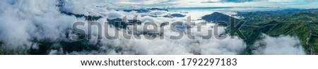 Aerial view of floating sea of clouds like cloud waves in mountains, Sea of fog, Sky above clouds, view on the mountain in the morning.