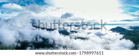 Aerial view of floating sea of clouds like cloud waves in mountains, Sea of fog, Sky above clouds, view on the mountain full of fog in the morning.