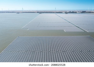 Aerial View Of Floating Solar Power Plant And  Wind Turbine Farm 