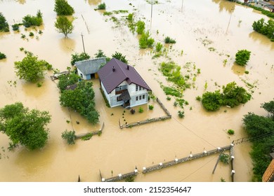 Aerial view of flooded house with dirty water all around it. - Shutterstock ID 2152354647