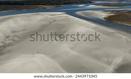 Aerial view of flowing water amidst the dunes.