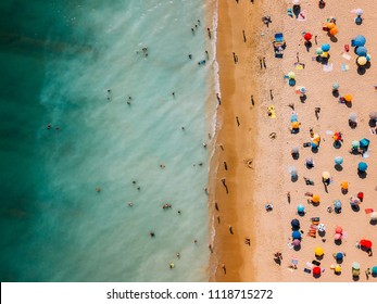 Aerial View From Flying Drone Of People Crowd Relaxing On Algarve Beach In Portugal