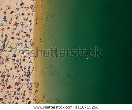 Aerial View From Flying Drone Of People Crowd Relaxing On Algarve Beach In Portugal