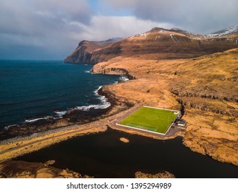 Aerial view of a football field from above with scenic mountain range covered in snow near the village Eidi (Faroe Islands, Denmark, Europe) - Powered by Shutterstock