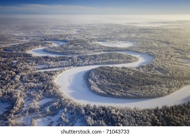 Aerial view of forest river in time of winter day.