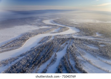 Aerial view of forest river in time of winter day.