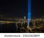 An aerial view of the Freedom Tower in New York City at night, while the tribute in light twin beams are illuminated.