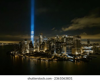 An aerial view of the Freedom Tower in New York City at night, while the tribute in light twin beams are illuminated.