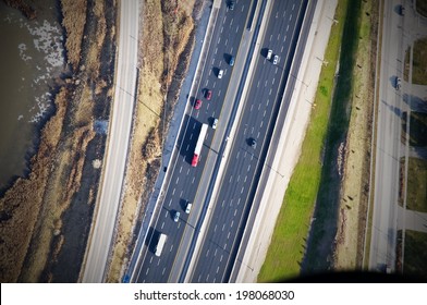 An Aerial View Of A Freeway Beside Some Water.