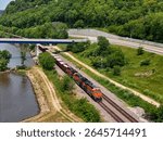 Aerial view of a freight train passing under the Dale Gardner Veterans Memorial Bridge along the Mississippi River at Savanna, Illinois