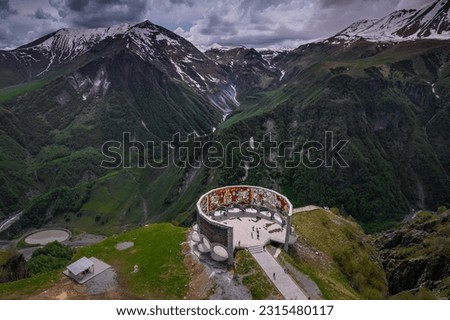 Aerial view of Russia–Georgia Friendship Monument located on the Georgian Military Highway between the ski resort town of Gudauri and the Jvari pass, overlooking the Devil's Valley in the Caucasus.