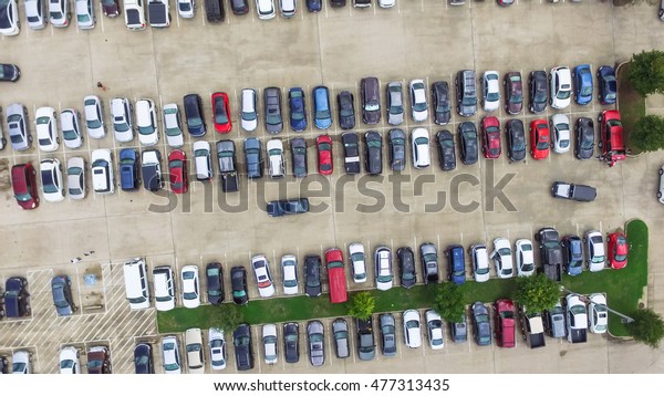 Aerial view full cars at large outdoor parking
lots in Houston, Texas, USA. Outlet mall parking congestion and
crowded parking lot, other cars try getting in and out, finding
parking space. Panorama