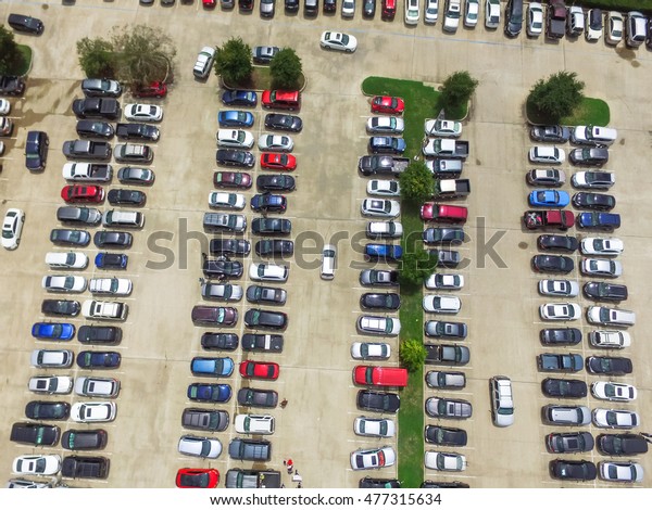 Aerial view full cars at large outdoor parking
lots in Houston, Texas, USA. Outlet mall parking congestion and
crowded parking lot with other cars try getting in and out, finding
parking space.