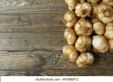 Aerial View Of Garlic Bulbs Arranged On A Rustic Wooden Kitchen Counter Background Forming A Page Border