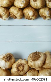 Aerial View Of Garlic Bulbs Arranged On A Painted Wooden Kitchen Counter Background Forming A Page Frame