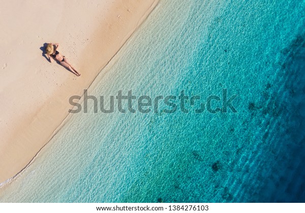 インドネシアのバリの海岸に住む少女の空撮 休暇と冒険 ビーチと青緑色の水 ビーチのドローン アズールシー リラックスガールからのトップビュー 移動と リラックス 画像 の写真素材 今すぐ編集