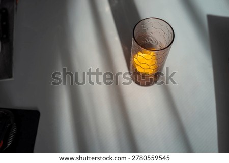 Aerial view of glass and shadows, hexpatterned glass with orange segment, diagonal sunbeams, highcontrast