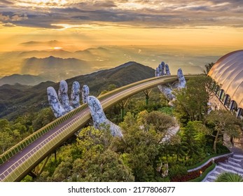 Aerial view of the Golden Bridge is lifted by two giant hands in the tourist resort on Ba Na Hill in Da Nang, Vietnam. Ba Na mountain resort is a favorite destination for tourists - Shutterstock ID 2177806877