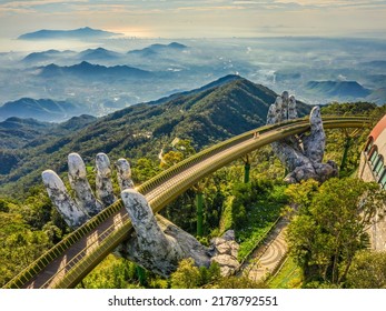 Aerial view of the Golden Bridge is lifted by two giant hands in the tourist resort on Ba Na Hill in Da Nang, Vietnam. Ba Na mountain resort is a favorite destination for tourists - Shutterstock ID 2178792551