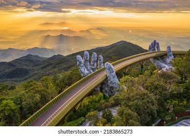 Aerial view of the Golden Bridge is lifted by two giant hands in the tourist resort on Ba Na Hill in Da Nang, Vietnam. Ba Na mountain resort is a favorite destination for tourists - Shutterstock ID 2183865273